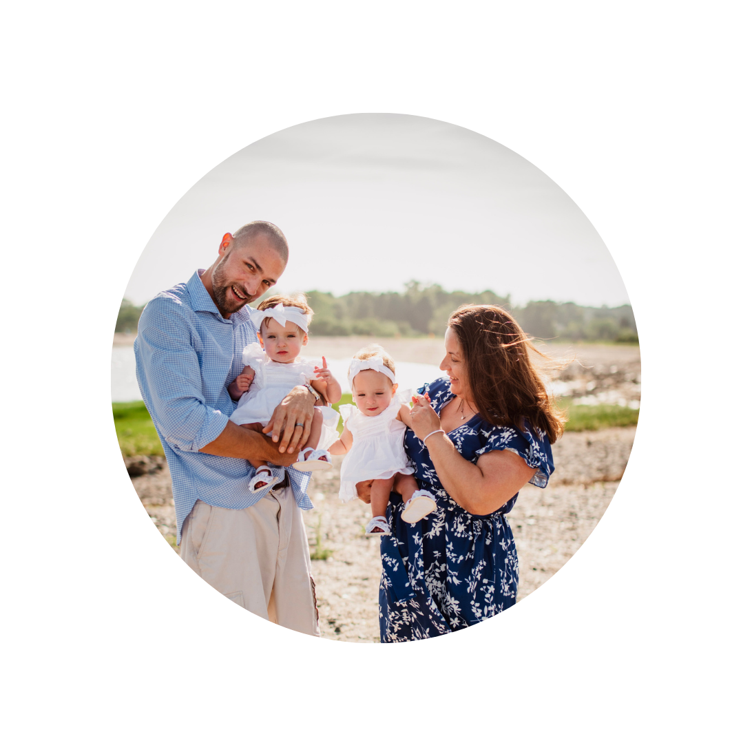 parents holding twin babies on beach