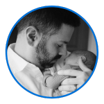 a black and white image of a father holding his newborn baby