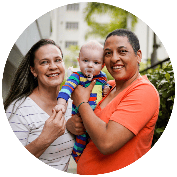 Lesbian moms holding baby smiling