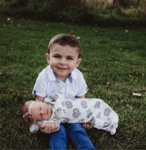 young boy holding his baby sister