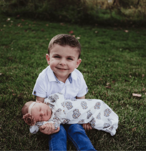 young boy holding his baby sister