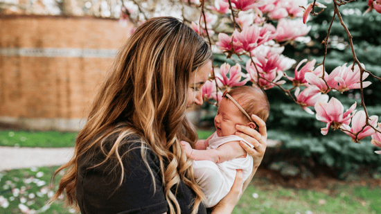 mom-holding-baby-in-front-of-flowers