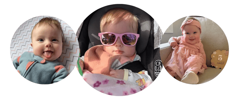 Kayleigh sticking out her tongue, wearing pink sunglasses, and sitting beside a five-month milestone sign.