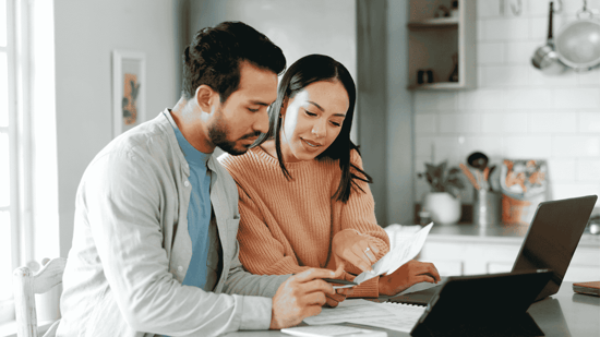 a couple sits in the kitchen reviewing egg donor costs for IVF treatment