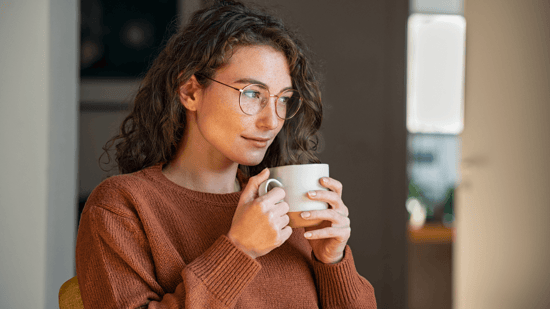 ivf do's and don'ts woman looking out window holding mug