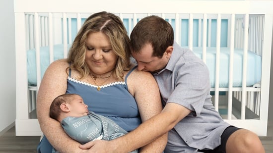 happy new parents hold their newborn son in his nursery after IVF journey