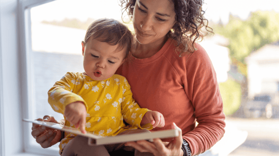 single mother by choice reading book to her baby